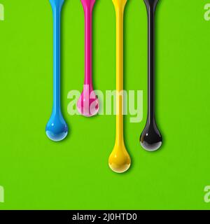 CMCMCMY-Tintentropfen auf quadratischen Hintergrund des grünen Papiers Stockfoto