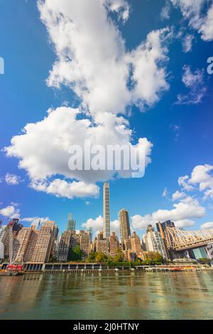 Am 2021. November schweben von Roosevelt Island aus große Wolken über dem Wolkenkratzer von Midtown Manhattan jenseits des East River. Stockfoto