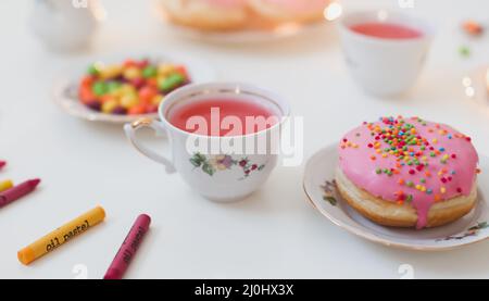 Urlaub, Geburtstagsfeier Komposition mit bunt rosa glasierten Donuts auf weißem Tisch, Flatlay Draufsicht. Stockfoto