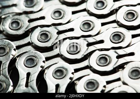 Muster einer technologischen Fahrradkette, umflochten in einen Kreis mit blau-violetter Beleuchtung Stockfoto