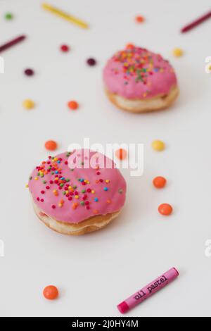 Urlaub, Geburtstagsfeier Komposition mit bunten rosa glasierten Donuts auf weiß. Stockfoto