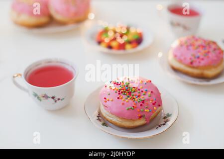 Urlaub, Geburtstagsfeier Komposition mit bunt rosa glasierten Donuts auf weißem Tisch, Flatlay Draufsicht. Stockfoto