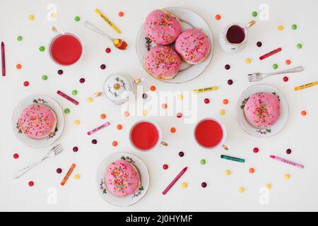 Urlaub, Geburtstagsfeier Komposition mit bunt rosa glasierten Donuts auf weißem Tisch, Flatlay Draufsicht. Stockfoto