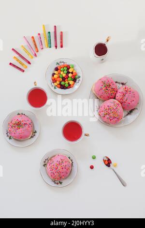 Urlaub, Geburtstagsfeier Komposition mit bunt rosa glasierten Donuts auf weißem Tisch, Flatlay Draufsicht. Stockfoto