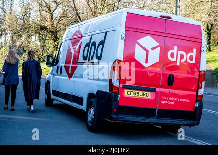 Epsom Surrey London, 19 2022. März, DPD Home Delivery Courier Van geparkt Lieferung von Paketen mit zwei Frauen, die vorbeigehen Stockfoto
