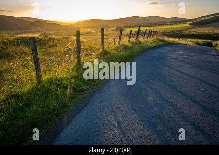 Country Road In Schottland Bei Sonnenuntergang Stockfoto