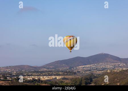 Bunte gelbe und rote Heißluftballons über blauem Himmel Stockfoto