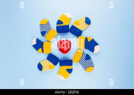 World Down Syndrome Day Hintergrund. Verschiedene Socken mit Herz auf blauem Hintergrund. Down-Syndrom-Bewusstsein-Konzept. Ungerade Socken als Symbol von Down Syndro Stockfoto