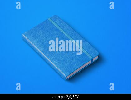 Blaues geschlossenes Notizbuch auf farbigem Hintergrund isoliert Stockfoto