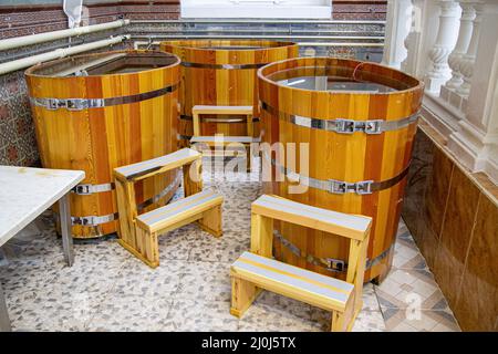 Hölzerne Badewannen im westlichen Stil in Fassform. Spa-Behandlungen Fässer Zedernbad in Holzdekor. Holzeimer Stockfoto