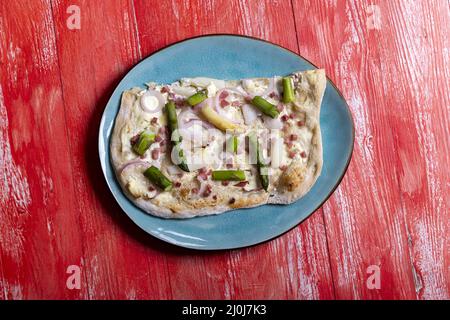 Französische Tarte flambÃ©e auf rotem Holz Stockfoto