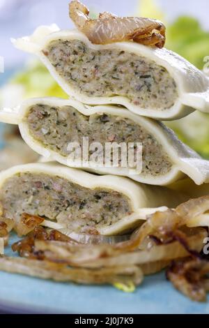 Hälften schwäbischer Maultaschen mit Salat Stockfoto