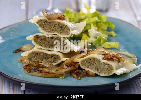 Hälften schwäbischer Maultaschen mit Salat Stockfoto