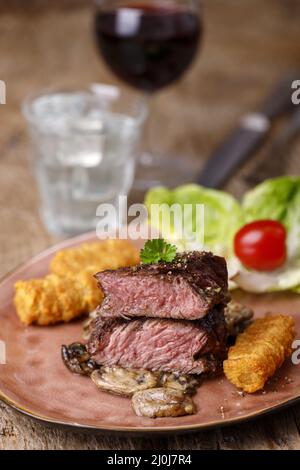 Steakscheiben mit Kroketten und Pilzen Stockfoto