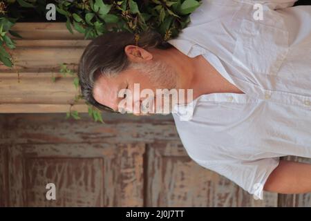 Vertikale Aufnahme eines kaukasischen bärtigen Mannes mit weißem Hemd Stockfoto