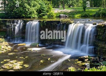 Eine idyllische Flusslandschaft im Wald mit einem Wasserfall Stockfoto