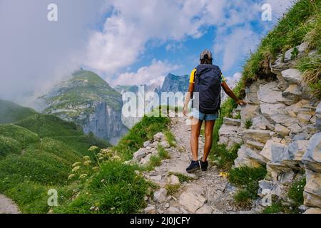 Eine Frau mit einem Rucksack steht auf einem Berg, das Mädchen reist an schöne Orte, das Ziel zu erreichen, Bergrücken an Stockfoto