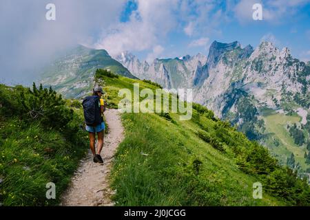 Eine Frau mit einem Rucksack steht auf einem Berg, das Mädchen reist an schöne Orte, das Ziel zu erreichen, Bergrücken an Stockfoto