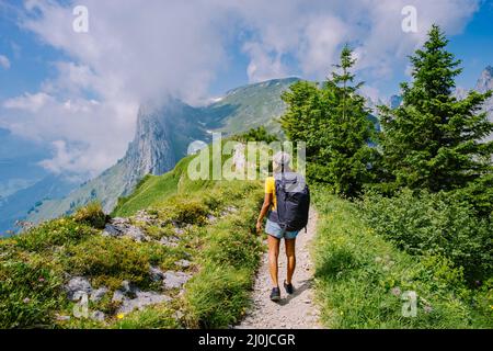 Eine Frau mit einem Rucksack steht auf einem Berg, das Mädchen reist an schöne Orte, das Ziel zu erreichen, Bergrücken an Stockfoto