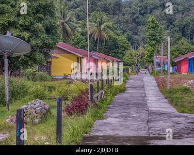 Kensi, Arguni, Indonesien - 01. Februar 2018: Bunte Holzhäuser in einem kleinen Dorf im indonesischen Tropenwald. Bird's Head Peninsula, West Stockfoto