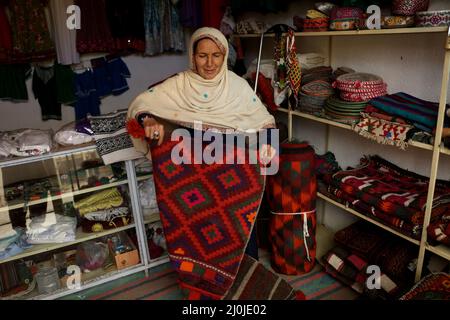 Bamiyan, Afghanistan. 19. März 2022. Am 19. März 2022 erwartet eine afghanische Frau am Art Bazaar in Bamiyan, Zentralafghan, Kunden. Quelle: Saifurahman Safi/Xinhua/Alamy Live News Stockfoto