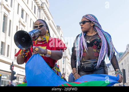 Anti-Rassismus-Protest auf den Straßen von London. Zwei weibliche schwarze Leben machen Protestierenden aus, die in ein Megaphon sprechen. London - 19.. März 2022 Stockfoto