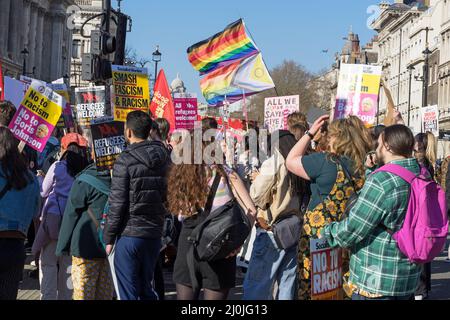 Anti-Rassismus-Protest auf den Straßen von London. Eine große Gruppe von Protestierenden, die Flüchtlinge halten, hält Willkommensschilder und LGBTQ-Flaggen. London - 19.. März 2022 Stockfoto