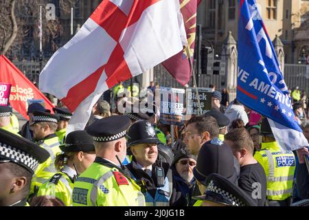 Ein paar rechtsextreme Demonstranten, die von der Polizei bei einem Anti-Rassismus-Protest auf dem Parliament Square umgeben sind. London - 19.. März 2022 Stockfoto