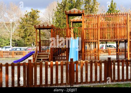 Schöne Rutschen auf einem Holzspielplatz im Freien an einem bewölkten Tag Stockfoto