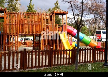 Schöne Rutschen auf einem Holzspielplatz im Freien an einem bewölkten Tag Stockfoto