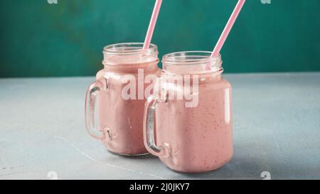 Erdbeermilchshake in Maurer-Gläsern mit frischen Erdbeeren Stockfoto