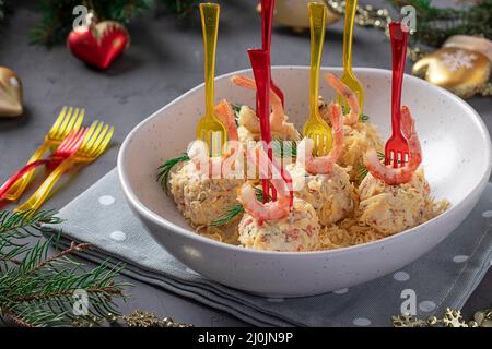 Käsebällchen mit Krabbenstäbchen und Garnelen - festlicher Snack zu Weihnachten und Neujahr auf grauem Tisch. Nahaufnahme Stockfoto