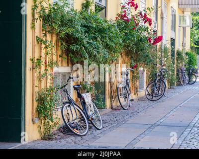 Kopenhagen, Dänemark - Juli, 2021: Zahlreiche Fahrräder, die auf dem Durchgang vor dem Gebäude in Kopenhagen geparkt sind. Europa. Stockfoto