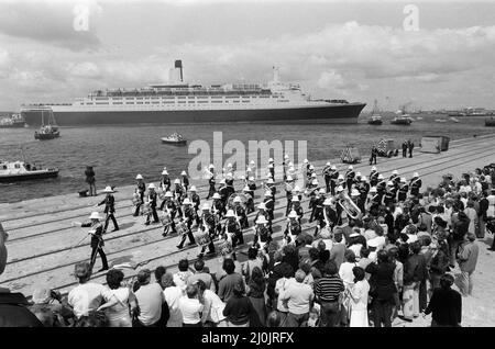 QE2 kehrt nach Southampton zurück. Union Jacks sind auf Autos festooniert, auf Schultern drapiert, auf Stöcken gewellt. Southampton begrüßt den Luxusliner aus dem Jahr QE2, der zum Trooper wurde und aus dem Krieg zurückkehrt, mit einem „Three Cheers“. An Bord ist ihre kostbare Fracht, die 700 Überlebenden der HMS Coventry, Ardent und Antelope, im Kampf um die Falklands versunken. 11.. Juni 1982. Stockfoto