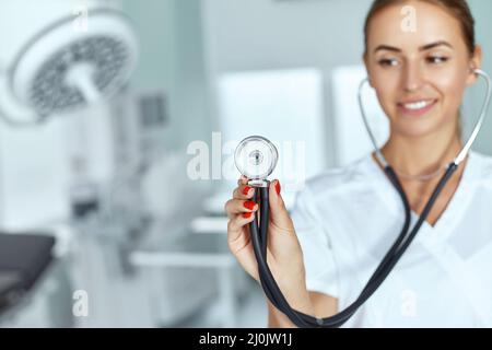 Ärztin mit Stethoskop in der Hand, medizinisches Pflegekonzept Stockfoto
