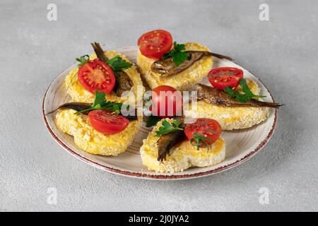 Sandwiches mit Sprossen, Käse, Ei- und Kirschtomaten in Form von Herzen auf grauem Hintergrund, Idee zum Valentinstag Stockfoto