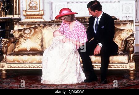 Prinzessin Diana, die von ihrem Ehemann Prinz Charles beobachtet wird, hält ihren Sohn Prinz William im White Drawing Room des Buckingham Palace nach einer privaten Taufe im Music Room in den Armen.der Prinz wurde im traditionellen Gewand aus Honiton-Spitze getauft. 4.. August 1982. Stockfoto