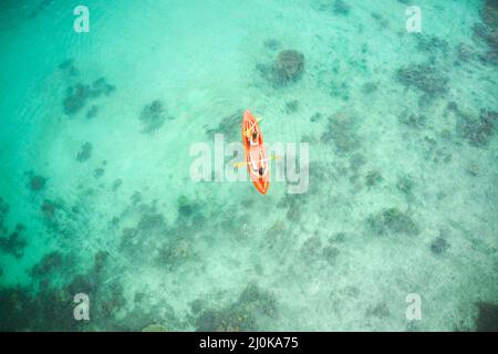Liebe ist ein Abenteuer, genießen Sie es. High-Angle-Aufnahme eines abenteuerlichen jungen Paares, das gemeinsam in den wunderschönen Ozeanen Indonesiens Kanu fahren kann. Stockfoto