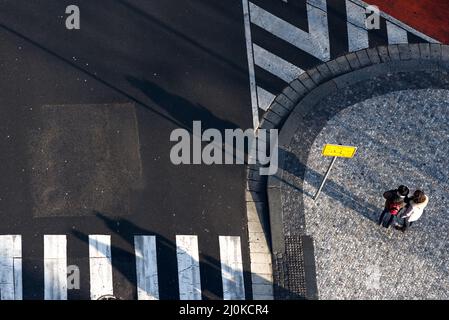 Zwei Personen durch Wegweiser finden ihren Weg in einer Stadt. High-Angle-Ansicht Stockfoto