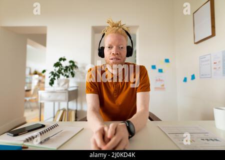 Albino-afroamerikanischer Mann, der von zu Hause aus arbeitet und Videoanruf macht Stockfoto