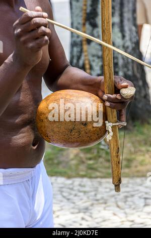 Musiker, der während einer Capoeira-Performance ein traditionelles brasilianisches Schlagzeuginstrument namens Berimbau spielt Stockfoto