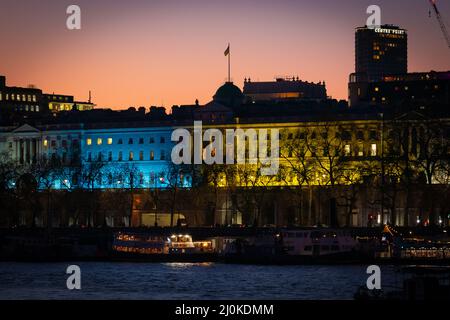 London, Großbritannien. 19.. März 2022. Somerset House von der Southbank-Seite aus gesehen, beleuchtet mit den Farben der Nationalflagge der Ukraine. Kredit: Guy Corbishley/Alamy Live Nachrichten Stockfoto