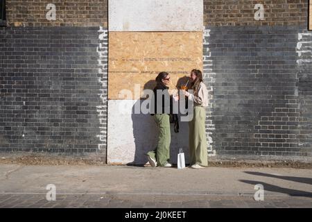 LONDON, DEN 12 2022. MÄRZ, treffen sich zwei Menschen, während sie am heißesten Tag des Jahres trinken, mit einer Temperatur von 19,3 Grad in einigen Teilen Großbritanniens. Stockfoto