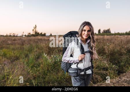 Junge Frau mit Rucksack, bereit zum Wandern. Telearbeit. Digitaler Nomade Stockfoto