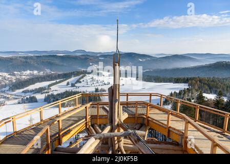 Die Winterlandschaft der Beskid-Berge vom Holzweg des Aussichtsturms auf der Skistation Slotwiny Arena in Krynica Zdroj, Polen aus gesehen Stockfoto