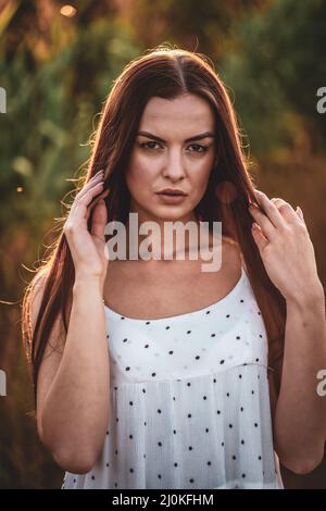 Junge schöne Frau in weißem Kleid im Maisfeld. Stockfoto