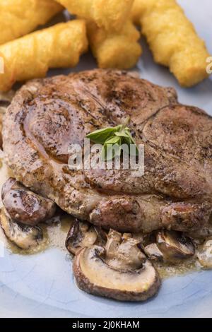 Nahaufnahme von Schweinesteak auf Pilzsauce Stockfoto