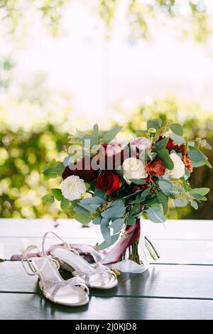 Brautstrauß aus weißen und roten Rosen, Pfingstrosen, Ästen von Eukalyptusbaum, Alstroemeria und Chrysantemum mit weiß und kastanienbraun Stockfoto