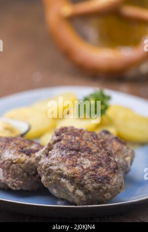 Bayerische Fleischbällchen mit Kartoffelsalat Stockfoto