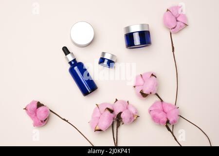 Braune Glasflaschen mit Pipette auf beigem Hintergrund. Kosmetik SPA Branding Mockup, Draufsicht Stockfoto